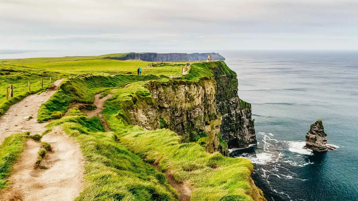 Ferry below the Cliffs of Moher on a day trip among the vacation tours of Ireland from Galway